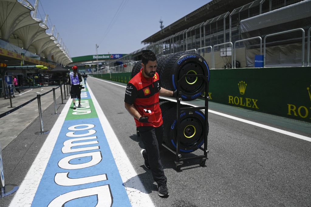 Mecânico da Ferrari carrega pneus no pit lane durante o primeiro dia do Grande Prêmio do Brasil de Fórmula 1 no Autódromo José Carlos Pace, mais conhecido como Interlagos, em São Paulo, Brasil, em 10 de novembro de 2022. (Foto de MAURO PIMENTEL / MAURO PIMENTEL/AFP)
