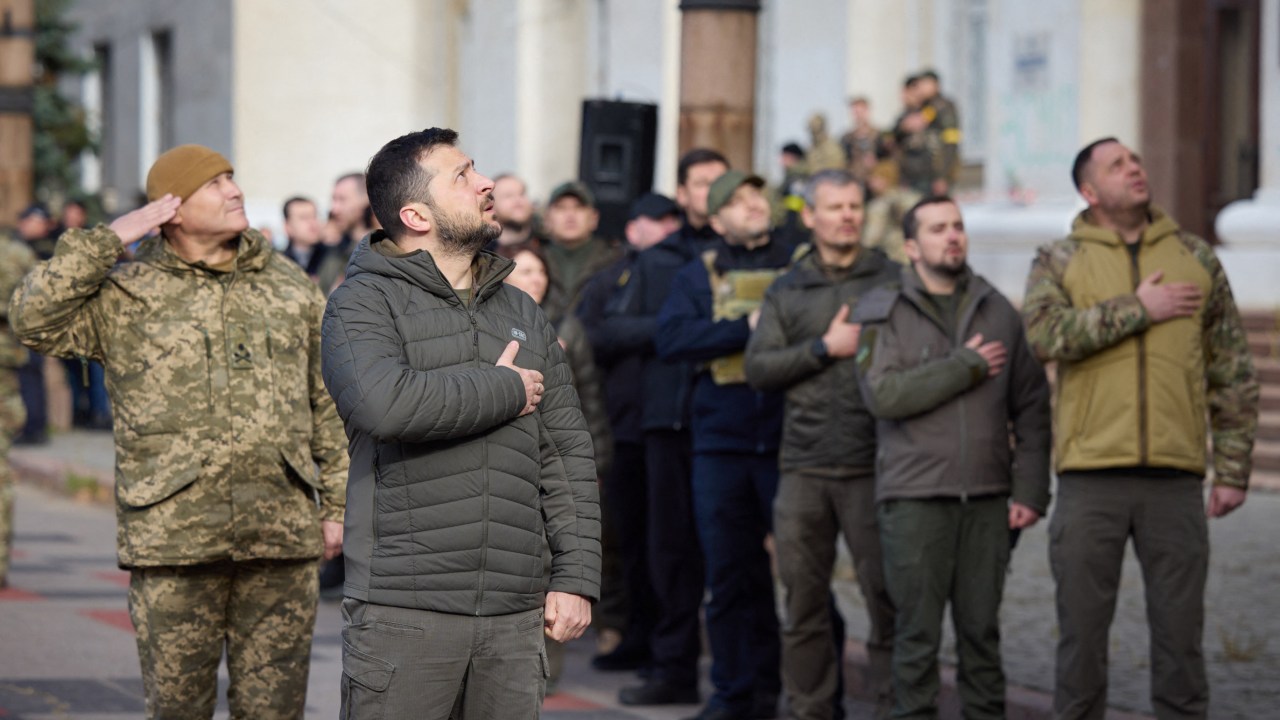 This handout photograph taken and released by Ukrainian Presidential press service on November 14, 2022, shows Ukrainian President Volodymyr Zelensky (2ndL) taking part in the flag laying ceremony during his visit to the newly liberated city of Kherson, following the retreat of Russian forces from the strategic hub. (Photo by Handout / UKRAINIAN PRESIDENTIAL PRESS SERVICE / AFP) / RESTRICTED TO EDITORIAL USE - MANDATORY CREDIT "AFP PHOTO / HO - UKRAINIAN PRESIDENTIAL PRESS SERVICE" - NO MARKETING NO ADVERTISING CAMPAIGNS - DISTRIBUTED AS A SERVICE TO CLIENTS