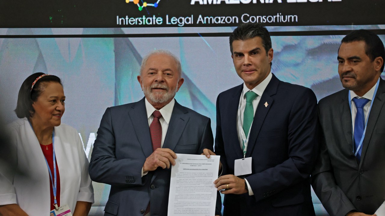 Brazilian president-elect Luiz Inacio Lula da Silva holds a document as he stands between Brazilian politicians Fatima Bezerra (L) and Helder Zahluth Barbalho (2nd R) during a discussion about the Amazon Forest at the COP27 climate conference in Egypt's Red Sea resort city of Sharm el-Sheikh on November 16, 2022. (Photo by JOSEPH EID / AFP)