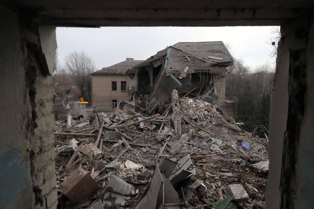 Rescuers clear debris of the destroyed two-storey maternity building in the town of Vilnyansk, southern Zaporizhzhia region, on November 23, 2022, amid the Russian invasion of Ukraine. - "As a result of a rocket attack on the territory of the local hospital, the two-storey building of the maternity ward was destroyed," they said in a statement. There was "a woman with a newborn baby as well as a doctor" inside the building at the time, they added. The baby died while the woman and doctor were rescued from the rubble, rescuers said. (Photo by Katerina Klochko / AFP)