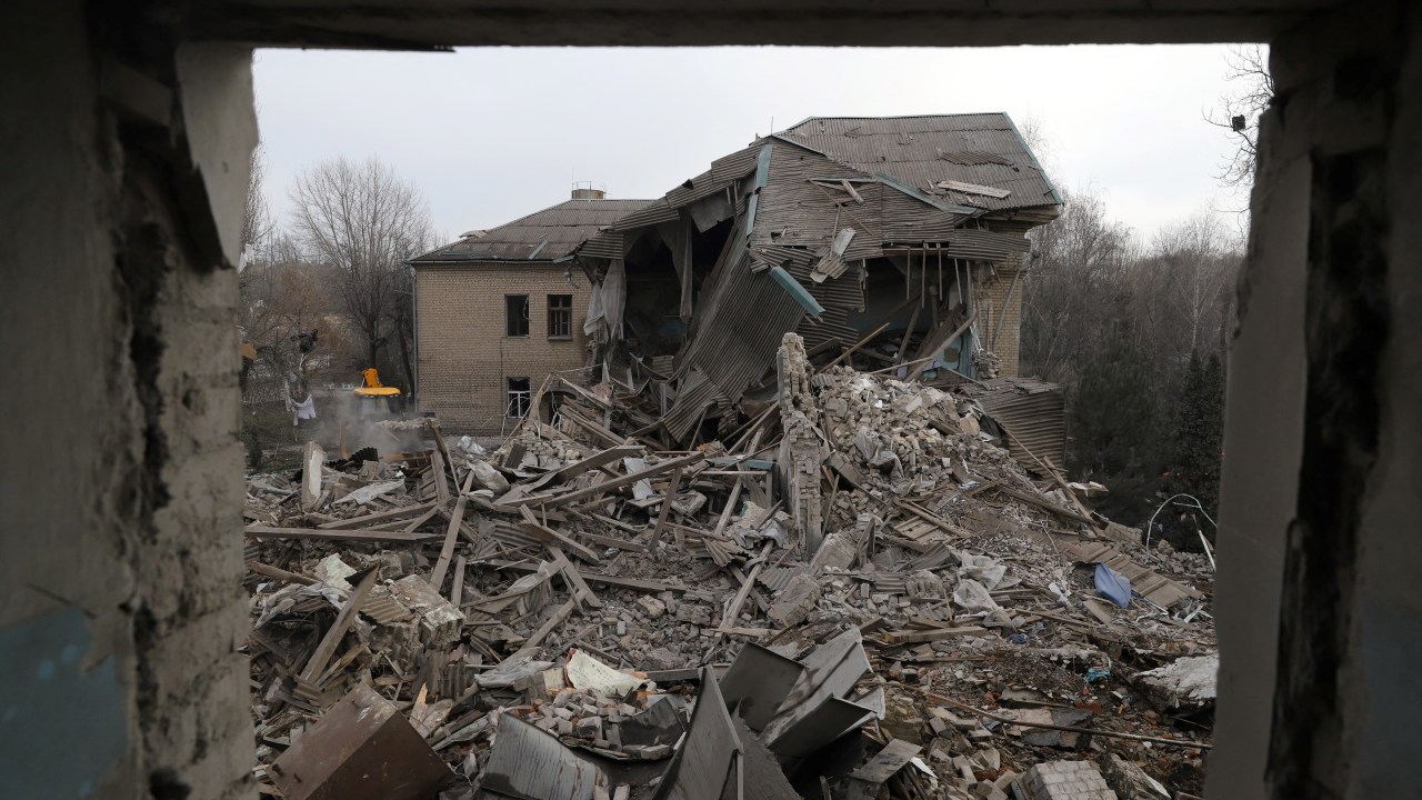 Rescuers clear debris of the destroyed two-storey maternity building in the town of Vilnyansk, southern Zaporizhzhia region, on November 23, 2022, amid the Russian invasion of Ukraine. - "As a result of a rocket attack on the territory of the local hospital, the two-storey building of the maternity ward was destroyed," they said in a statement. There was "a woman with a newborn baby as well as a doctor" inside the building at the time, they added. The baby died while the woman and doctor were rescued from the rubble, rescuers said. (Photo by Katerina Klochko / AFP)