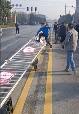 Captura de imagem tirada de um vídeo da Afp e postada em 23 de novembro de 2022 mostra trabalhadores da fábrica de iPhone da Foxconn em Zhengzhou, no centro da China, em confronto com a polícia de choque, bem como pessoas vestindo trajes de proteção. Os confrontos começaram depois que os funcionários reclamaram dos salários e das condições da fábrica.Equipes AFPTV / AFP