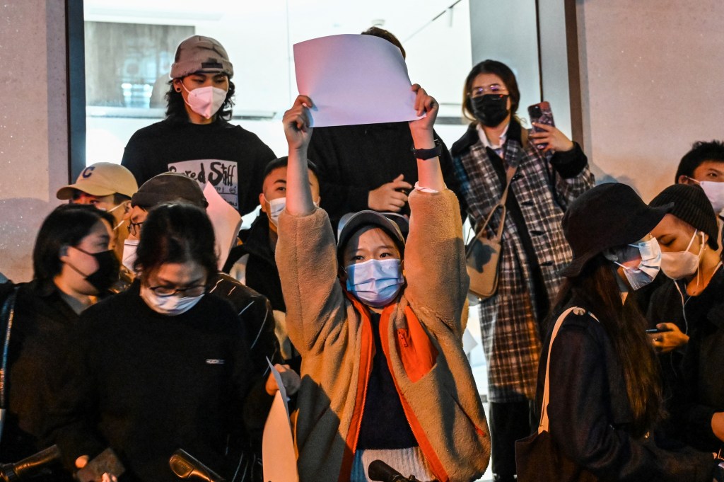 People show blank papers as a way to protest, is seen on a wall while gathering on a street in Shanghai on November 27, 2022, where protests against China's zero-Covid policy took place the night before following a deadly fire in Urumqi, the capital of the Xinjiang region. (Photo by Hector RETAMAL / AFP)