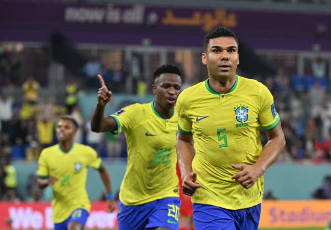 Brazil's midfielder #05 Casemiro (R) celebrates with Brazil's forward #20 Vinicius Junior after he scored his team's first goal during the Qatar 2022 World Cup Group G football match between Brazil and Switzerland at Stadium 974 in Doha on November 28, 2022. (Photo by NELSON ALMEIDA / AFP)