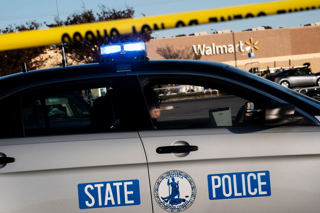 CHESAPEAKE, VA - NOVEMBER 23: A Virginia State Police officer watches the police line set up at the site of Tuesdays fatal shooting at the Chesapeake Walmart Supercenter on November 23, 2022 in Chesapeake, Virginia. Six people, including the suspected gunman, are dead following the Tuesday night shooting. (Photo by Nathan Howard/Getty Images)
