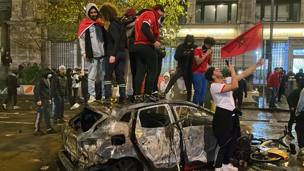 Torcedores posam sobre um carro incendiado em Bruxelas, na Bélgica -
