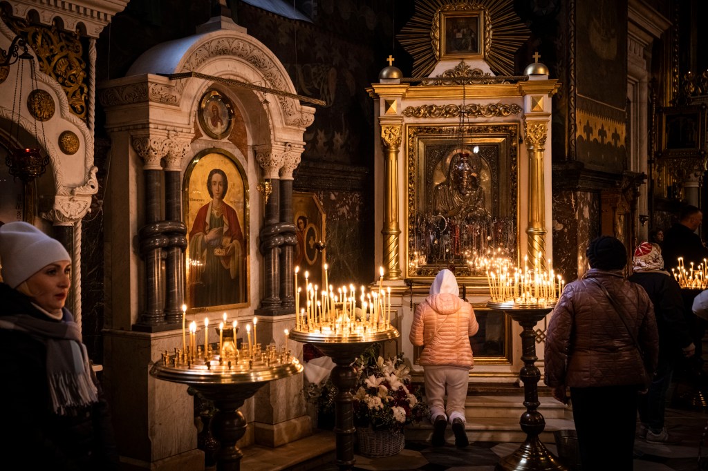 KYIV, UKRAINE - NOVEMBER 06: Worshippers pray and light candles in St. Volodymyr's Cathedral, the Ukrainian Orthodox Church of the Kyiv Patriarchate, on Sunday November 06, 2022 in Kyiv, Ukraine. Electricity and heating outages across Ukraine caused by missile and drone strikes to energy infrastructure have added urgency preparations for winter. (Photo by Ed Ram/Getty Images)