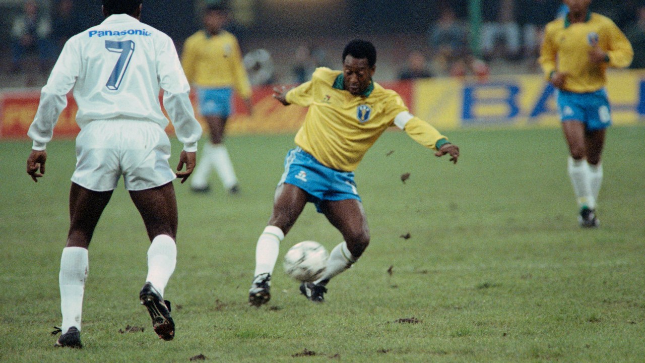 (FILES) In this file photo taken on October 31, 1990 Former Brazilian soccer star, Edson Arantes do Nascimento, known as Pelé (L), plays the ball during a friendly soccer match opposing Brazil to world soccer star to celebrate Pele's fiftieth birtday in Milan. - Brazilian football icon Pele, widely regarded as the greatest player of all time and a three-time World Cup winner who masterminded the 'beautiful game', died on December 29, 2022 at the age of 82, after battling kidney problems and colon cancer. (Photo by Gerard MALIE / AFP)
