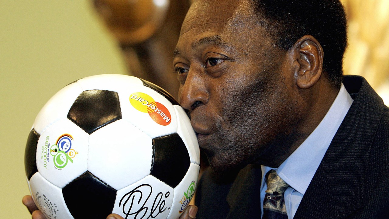 (FILES) In this file photo taken on December 08, 2005, Brazilian football legend Pele kisses a ball, during a presentation in Leipzig on the eve of the final draw of the Fifa football World Cup 2006. - The hospital treating Brazilian football great Pele announced on December 21, 2022, a "progression" in his cancer, as well as kidney and heart "dysfunctions." Pele, 82, is being treated in the general ward but "requires greater care related to renal and cardiac dysfunctions," said the Albert Einstein Hospital in Sao Paulo. (Photo by Franck FIFE / AFP)