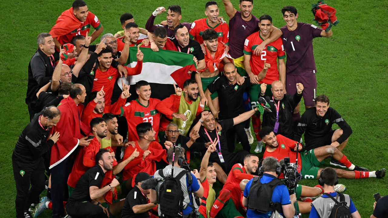 Morocco's players celebrate at the end of the Qatar 2022 World Cup round of 16 football match between Morocco and Spain at the Education City Stadium in Al-Rayyan, west of Doha on December 6, 2022. (Photo by Glyn KIRK / AFP)