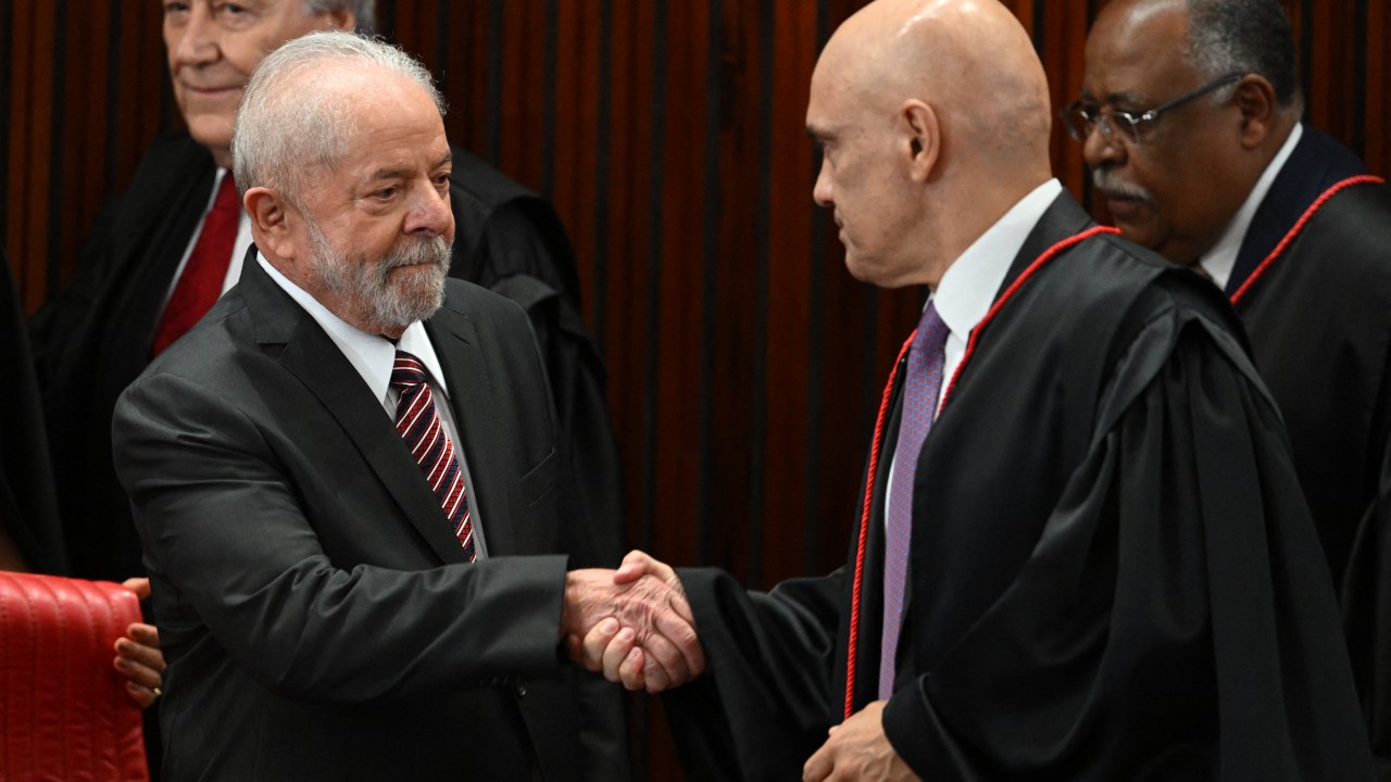 Brazil's President-elect Luiz Inacio da Silva (L) shakes hands with the President of the Superior Electoral Court (TSE) Alexandre de Moraes (R) while attending the certification ceremony at the TSE headquarters in Brasilia, December 12, 2022. - Luiz Inacio Lula da Silva received this Monday the "diploma" of President-elect from the highest electoral authority in Brazil, which formalizes his path to take office on January 1, 2023. (Photo by EVARISTO SA / AFP)