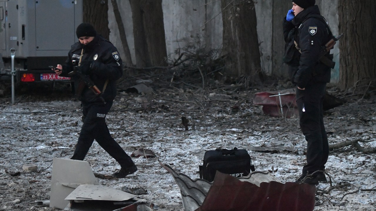 Rescuers and police experts examine remains of a drone following a strike on an administrative building in the Ukrainian capital Kyiv on December 14, 2022. - President Volodymyr Zelensky said on December 14, 2022, that Ukrainian air defence systems had shot down 13 Iranian-made kamikaze drones that targeted the capital Kyiv earlier in the day. (Photo by Sergei SUPINSKY / AFP)