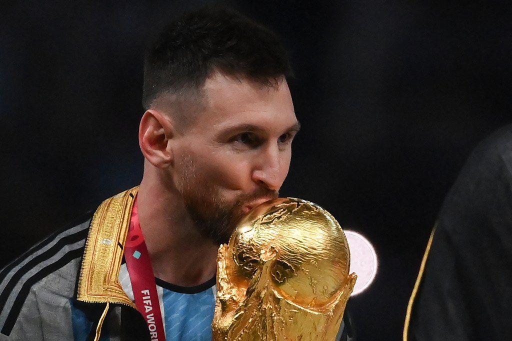 Argentina's forward #10 Lionel Messi kisses the World Cup trophy during the Qatar 2022 World Cup trophy ceremony after the football final match between Argentina and France at Lusail Stadium in Lusail, north of Doha on December 18, 2022. - Argentina won in the penalty shoot-out. (Photo by FRANCK FIFE / AFP)