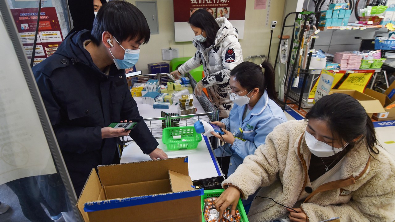 A man buys fever medicine at a pharmacy amid the Covid-19 pandemic in Nanjing, in China's eastern Jiangsu province, on December 19, 2022, as the pharmacy offers six capsules for each client. (Photo by AFP) / China OUT