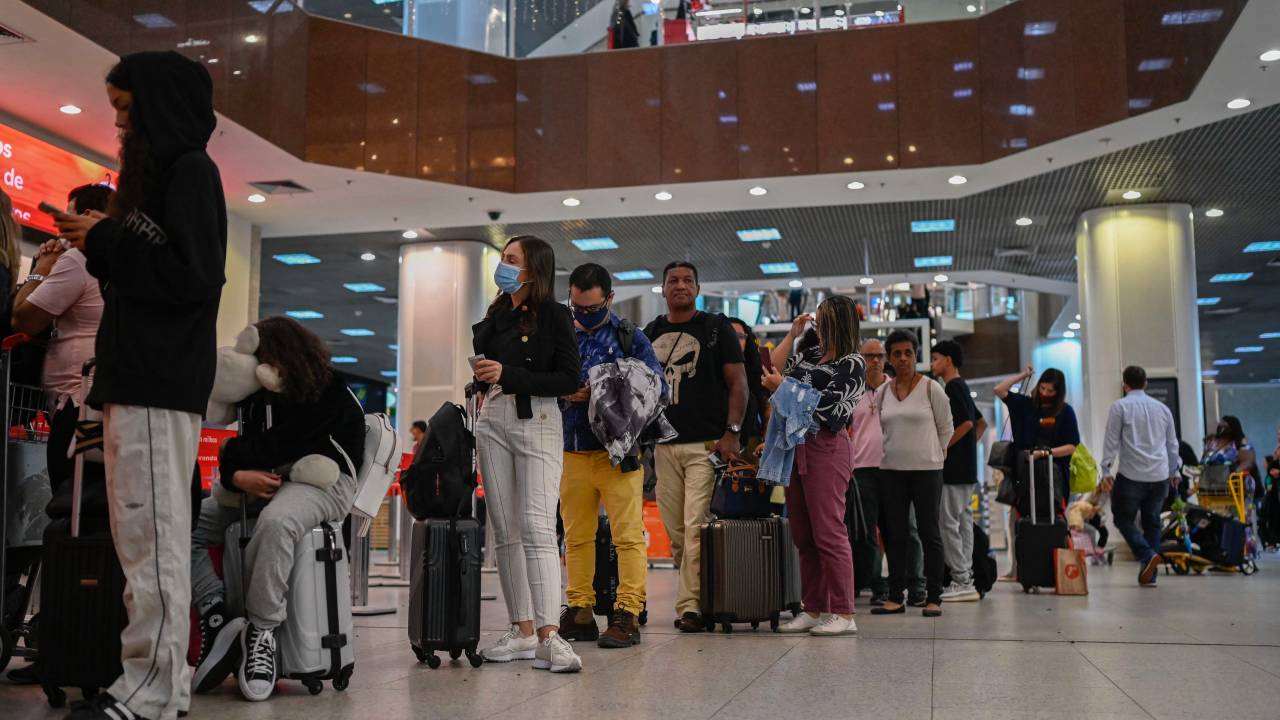 Passangers queue to do their check-in at the boarding area of the Santos Dumont Ariport in Rio de Janeiro, Brazil on December 20, 2022. - A pilot strike is taking place around several Brazilian airports prior the end of the year festivities demanding better salaries and work conditions. (Photo by MAURO PIMENTEL / AFP)