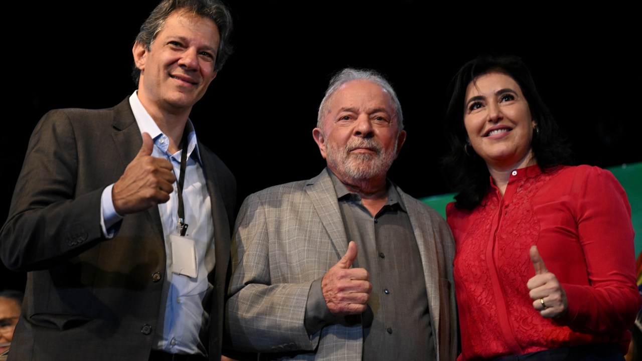 Brazil's President-elect Luiz Inacio Lula da Silva (C), future Minister of Economy Fernando Haddad (L) and future Minister of Planning Simone Tebet (R) pose for a picture during a press conference at the transitional government building in Brasilia on December 29, 2022. - Luiz Inacio Lula da Silva appointed this Thursday the environmentalist Marina Silva as Minister of Environment, and the indigenous leader Sonia Guajajara at the head of the unprecedented portfolio of Original Peoples, completing his cabinet three days before beginning his third presidential term in Brazil. (Photo by EVARISTO SA / AFP)