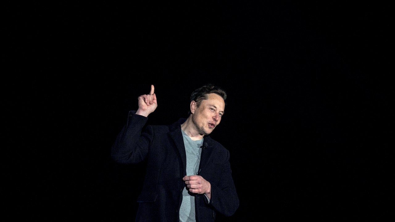 Elon Musk gestures as he speaks during a press conference at SpaceX's Starbase facility near Boca Chica Village in South Texas on February 10, 2022. - Billionaire entrepreneur Elon Musk delivered an eagerly-awaited update on SpaceX's Starship, a prototype rocket the company is developing for crewed interplanetary exploration. (Photo by JIM WATSON / AFP)