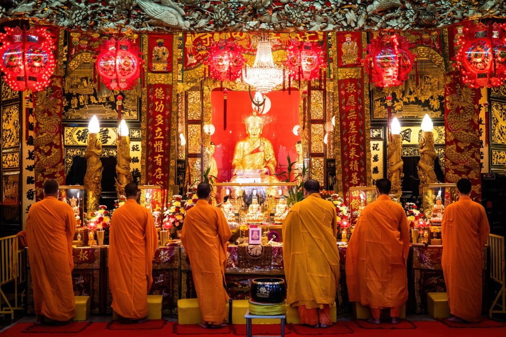 Monges budistas rezam durante uma cerimônia em um templo em Chinatown de Bangkok, na Tailândia.