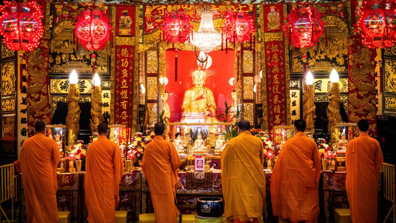 Monges budistas rezam durante uma cerimônia em um templo em Chinatown de Bangkok, na Tailândia.