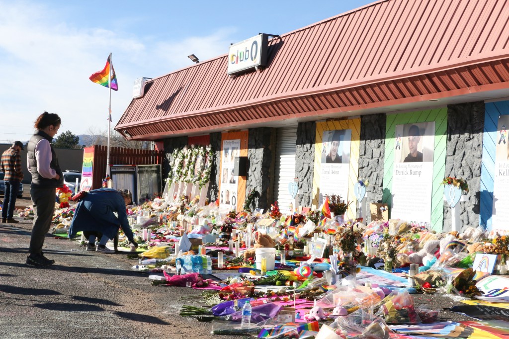 COLORADO SPRINGS, UNITED STATES - 2022/11/26: Mourners take photos and place flowers at the Club Q memorial. The Club Q shooting memorial continues growing one week after a mass shooter took five lives and injured 18 others on Nov. 19 at an LGBTQ club in Colorado Springs. (Photo by Brett Forrest/SOPA Images/LightRocket via Getty Images)