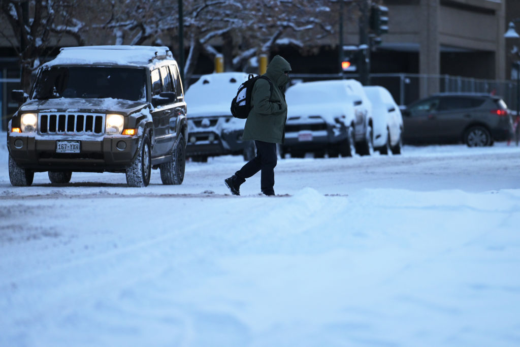 DENVER, CO - DECEMBER 22 : A pedestrian across snow-covered 13th Ave. near the corner of Grant St. in Denver, Colorado on Thursday, December 22, 2022. (Photo by Hyoung Chang/The Denver Post)