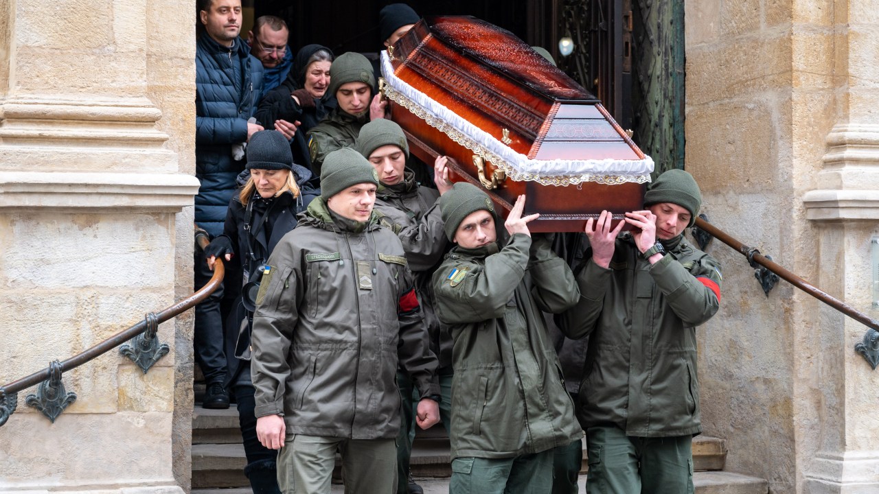 LVIV, UKRAINE - NOVEMBER 28: Soldiers of the honor guard carry the coffin after the service in the Garrison Temple on November 28, 2022 in Lviv, Ukraine. On Monday, November 28, defender of Ukraine Denys Metyolkin was buried in Lviv. The funeral ceremony took place in the Garrison Church. Denys Metyolkin is a native of the city of Severodonetsk, Luhansk region. The defender was 39 years old. Denys Metyolkin served as part of the 68th separate hunting brigade of the Ground Forces Reserve Corps of the Armed Forces of Ukraine. (Photo by Stanislav Ivanov/Global Images Ukraine via Getty Images)