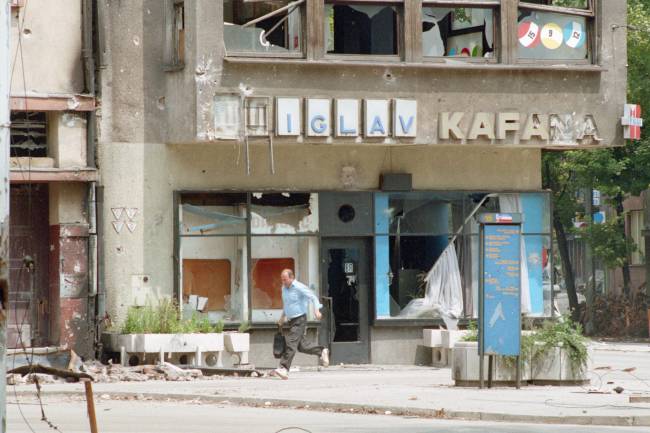 Homem bósnio corre em Sarajevo durante a guerra civil