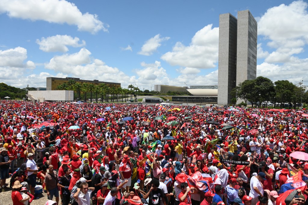 Supporters of President-elect Luiz Inacio Lula da Silva gather to wait for his inauguration ceremony at "Tres Poderes" square in front of the Planalto Palace in Brasilia, on January 1, 2023. - Lula da Silva, a 77-year-old leftist who already served as president of Brazil from 2003 to 2010, takes office for the third time with a grand inauguration in Brasilia. (Photo by EVARISTO SA / AFP)