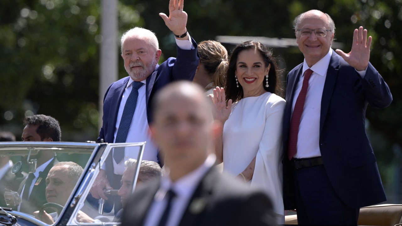 Brazil's President-elect Luiz Inacio Lula da Silva (L) waves to supporters accompanied by his wife Rosangela da Silva (2-L), his Vice-President-elect Geraldo Alckmin (R), and his wife, Maria Lucia Ribeiro Alckmin, on their way to the National Congress for their inauguration ceremony, in Brasilia, on January 1, 2023. - Lula da Silva, a 77-year-old leftist who already served as president of Brazil from 2003 to 2010, takes office for the third time with a grand inauguration in Brasilia. (Photo by DOUGLAS MAGNO / AFP)