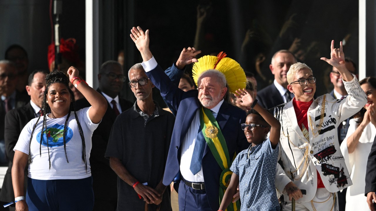 Brazil's new President Luiz Inacio Lula da Silva waves after receiving the presidential sash at Planalto Palace after his inauguration ceremony at the National Congress, in Brasilia, on January 1, 2023. - Lula da Silva, a 77-year-old leftist who already served as president of Brazil from 2003 to 2010, takes office for the third time with a grand inauguration in Brasilia. (Photo by EVARISTO SA / AFP)