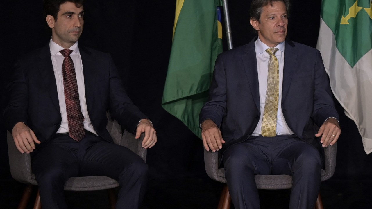 Finance Minister Fernando Haddad (C), accompanied by Executive Secretary Gabriel Galipolo (L) and Attorney General of the National Treasury Anelize Lenzi de Almeida (R) attends his swearing-in ceremony at the Centro Cultural Banco do Brasil in Brasilia, on January 2, 2023. (Photo by DOUGLAS MAGNO / AFP)