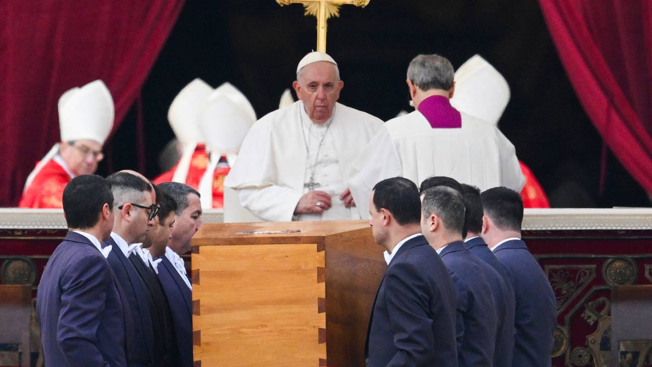 Pope Pope Francis looks on as pallbearers carry away the coffin of Pope Emeritus Benedict XVI at the end of his funeral mass at St. Peter's square in the Vatican on January 5, 2023. - Pope Francis is presiding on January 5 over the funeral of his predecessor Benedict XVI at the Vatican, an unprecedented event in modern times expected to draw tens of thousands of people. (Photo by Vincenzo PINTO / AFP)