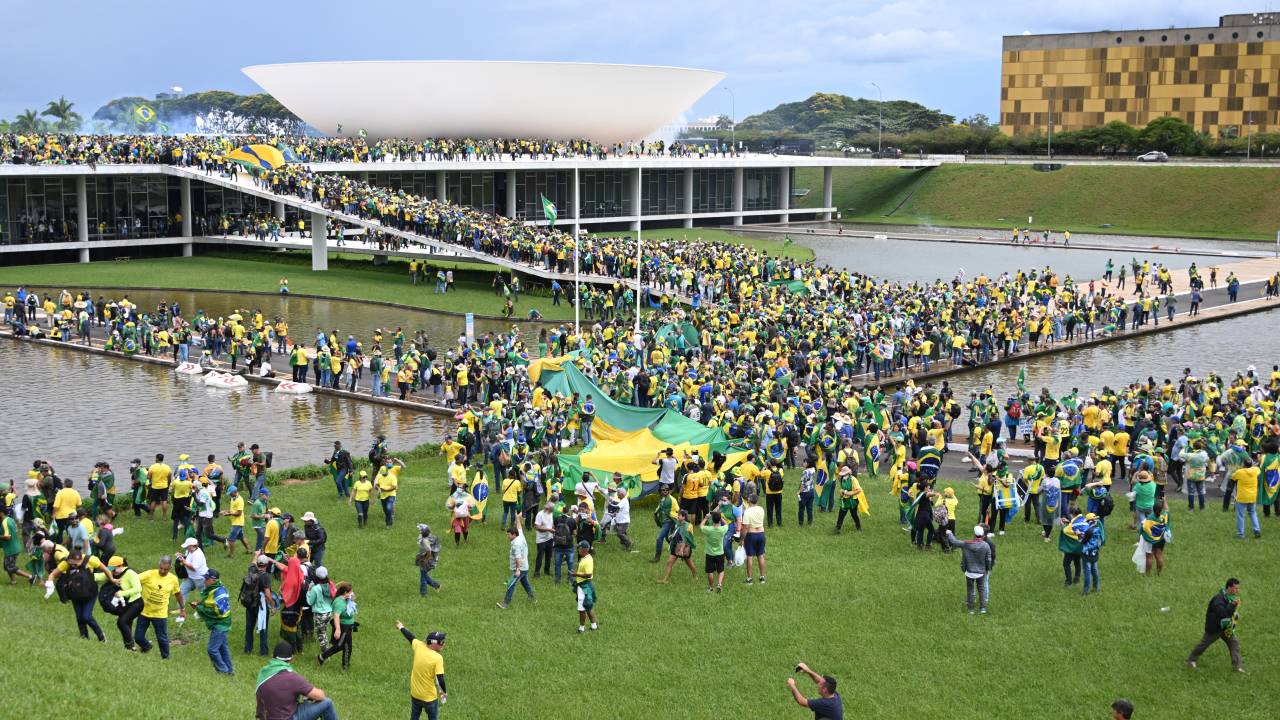 Supporters of Brazilian former President Jair Bolsonaro hold a demonstration at the Esplanada dos Ministerios in Brasilia on January 8, 2023. - Brazilian police used tear gas Sunday to repel hundreds of supporters of far-right ex-president Jair Bolsonaro after they stormed onto Congress grounds one week after President Luis Inacio Lula da Silva's inauguration, an AFP photographer witnessed. (Photo by EVARISTO SA / AFP)