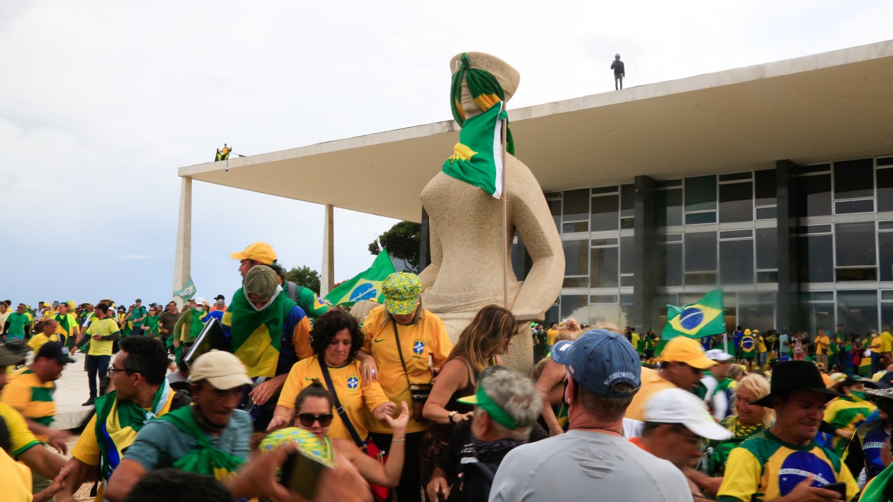 Supporters of Brazilian former President Jair Bolsonaro invade Planalto Presidential Palace while clashing with security forces in Brasilia on January 8, 2023. - Hundreds of supporters of Brazil's far-right ex-president Jair Bolsonaro broke through police barricades and stormed into Congress, the presidential palace and the Supreme Court Sunday, in a dramatic protest against President Luiz Inacio Lula da Silva's inauguration last week. (Photo by Sergio Lima / AFP)
