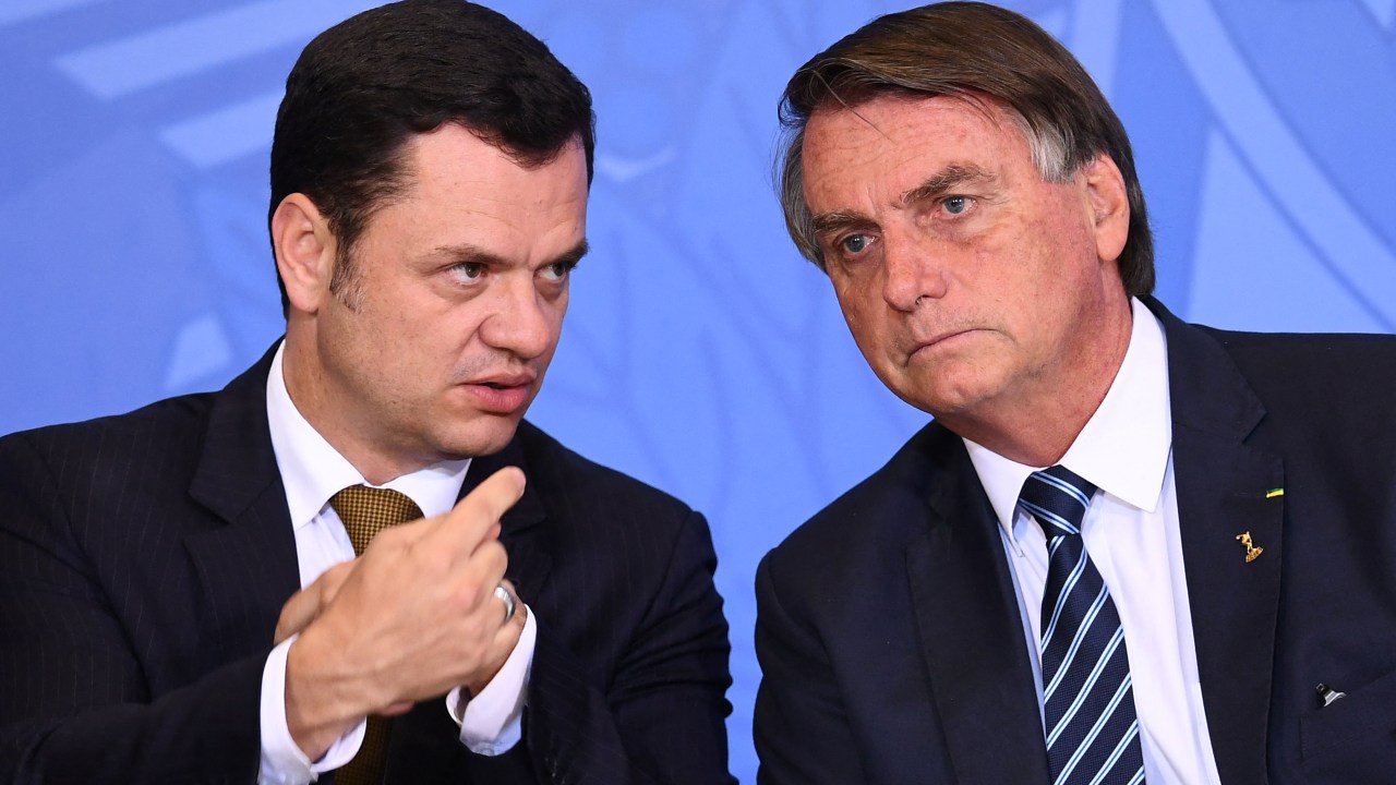 (FILES) In this file photo taken on June 27, 2022, Brazilian President Jair Bolsonaro (L) and his Minister of Justice Anderson Torres talk during an event to present the new national ID and passport at Planalto Palace in Brasilia. - Brazilian President Luiz Inacio Lula da Silva won strong backing from Brazil's political and judicial powers on January 9, 2023, a day after supporters of the far-right former president Jair Bolsonaro invaded official buildings in the capital, causing severe damage. (Photo by EVARISTO SA / AFP)