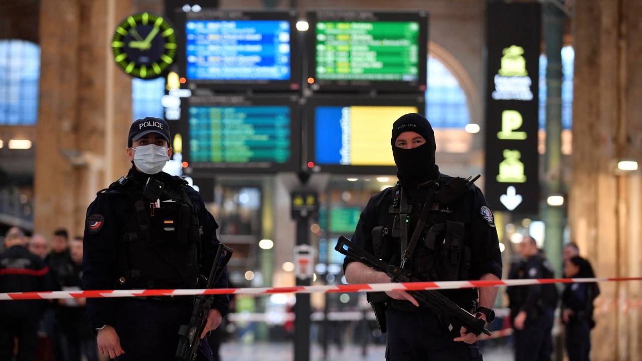 French police stand guard in a cordonned off area at Paris' Gare du Nord train station, after several people were lightly wounded by a man wielding a knife on January 11, 2023. - The man was arrested by police at the station, which serves as a hub for trains to London and northern Europe, after they opened fire and wounded him, said a police source, who asked not to be named. (Photo by JULIEN DE ROSA / AFP)