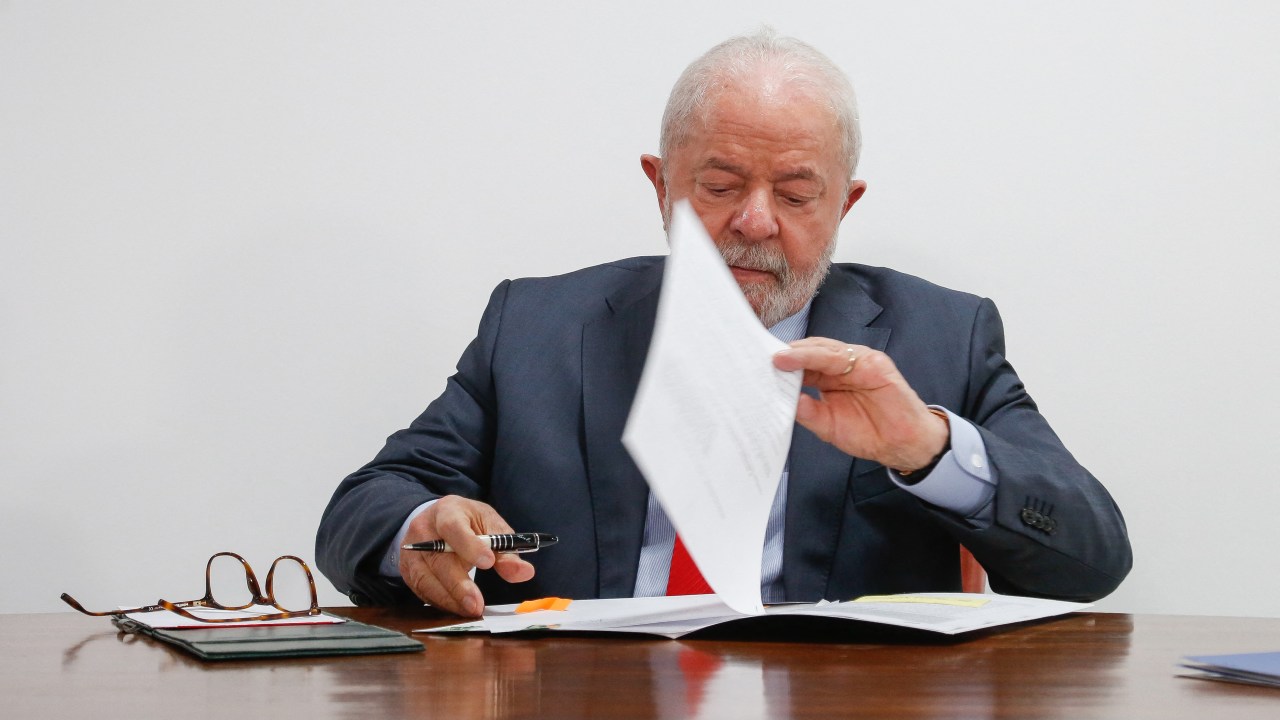 Brazil's President Luiz Inacio Lula da Silva signs a document of new economic measures at the Planalto Palace in Brasilia, on January 12, 2023. (Photo by Sergio Lima / AFP)