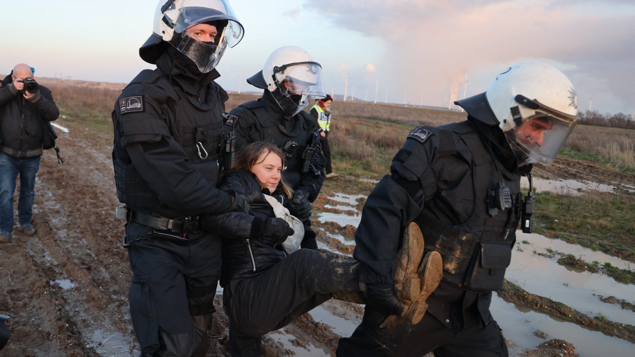Police officers carry Swedish climate activist Greta Thunberg (C) out of a group of demonstrators and activists in Erkelenz, western Germany, on January 17, 2023, as demonstrations continue against a coal mine extension in the nearby village of Luetzerath. - Already abandoned by its original residents, Luetzerath has become a symbol for resistance against fossil fuels. Energy giant RWE has permission for the expansion of the mine under a compromise agreement that also includes that RWE will stop producing electricity with coal in western Germany by 2030 -- eight years earlier than previously planned. With Russia's gas supply cut in the wake of the invasion of Ukraine, Germany has had recourse to coal, firing up mothballed power plants. (Photo by Christoph Reichwein / dpa / AFP) / Germany OUT