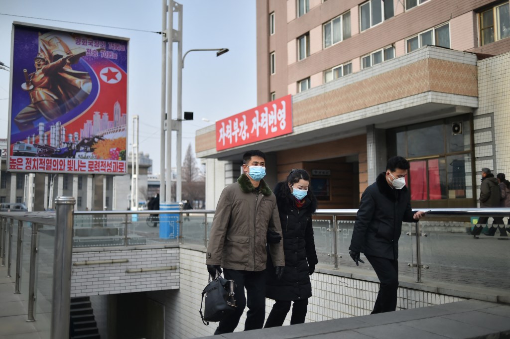 Pessoas de máscara caminham em Pyongyang. 22/01/2023