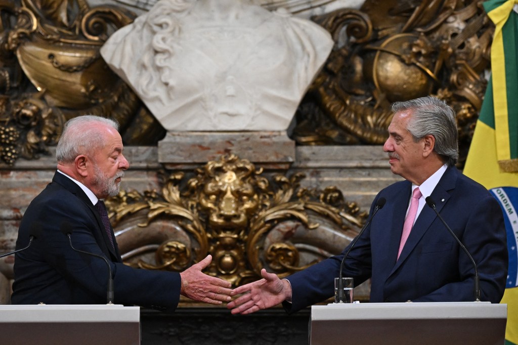 Brazilian President Luiz Inacio Lula da Silva (L) and Argentine President Alberto Fernandez (R) shake hands during a press conference at the Casa Rosada presidential palace in Buenos Aires on January 23, 2023. - Brazil's President Luiz Inacio Lula da Silva began his first international tour last Sunday with a visit to Argentina and Uruguay with the aim of restoring regional leadership to Brazil after the management of the far-right Jair Bolsonaro. (Photo by Luis ROBAYO / AFP)
