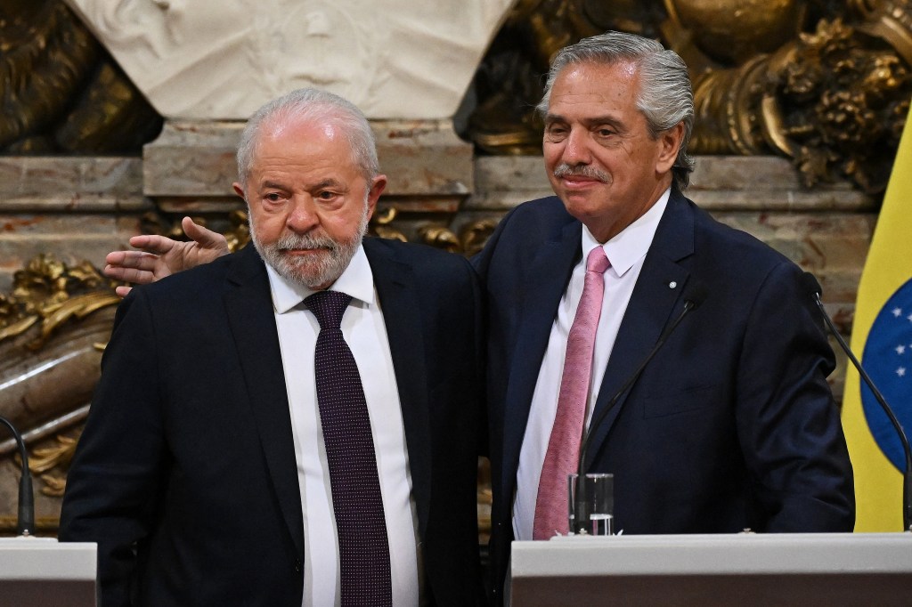 Brazilian President Luiz Inacio Lula da Silva (L) and Argentine President Alberto Fernandez (R) hug during a press conference at the Casa Rosada presidential palace in Buenos Aires on January 23, 2023. - Brazil's President Luiz Inacio Lula da Silva began his first international tour last Sunday with a visit to Argentina and Uruguay with the aim of restoring regional leadership to Brazil after the management of the far-right Jair Bolsonaro. (Photo by Luis ROBAYO / AFP)