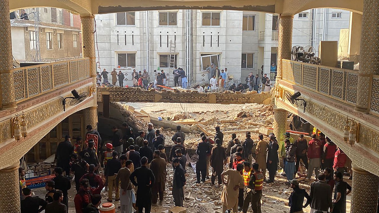 Security officials inspect the site of a mosque blast inside the police headquarters in Peshawar on January 30, 2023. - At least 17 people were killed in a mosque blast at a police headquarters in Pakistan, a hospital official said. (Photo by Maaz ALI / AFP)