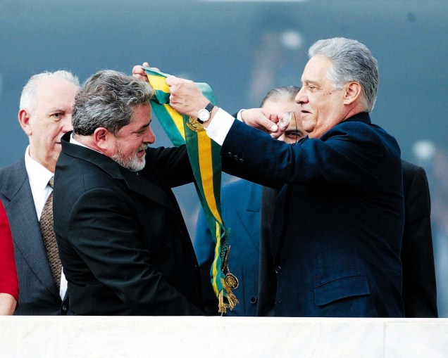 O presidente eleito Luiz Inácio Lula da Silva recebe de FHC a faixa de presidente da República no parlatório do Palácio do Planalto, em janeiro de 2003 -