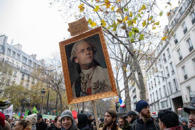 A protester holds a caricature painting depicting France’s President Emmanuel Macron as a former French king during a national strike in Paris, France, on Thursday, Dec. 5, 2019.