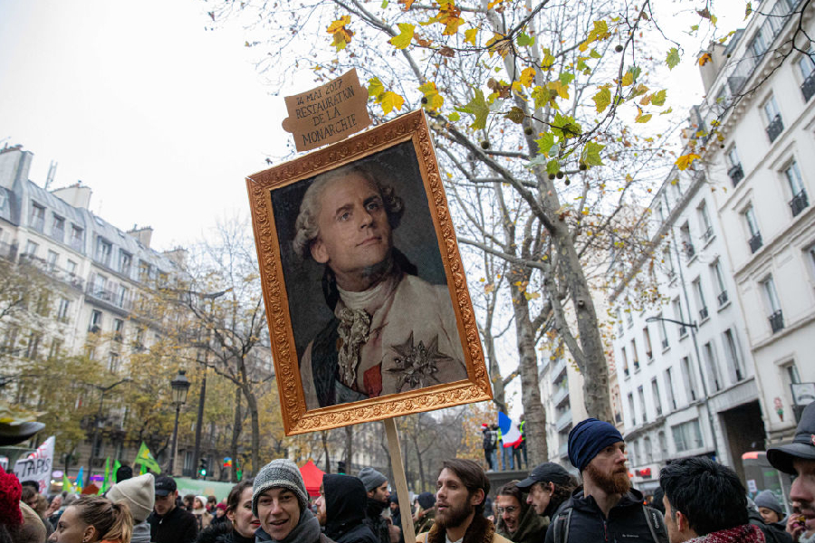 A protester holds a caricature painting depicting France's President Emmanuel Macron as a former French king during a national strike in Paris, France, on Thursday, Dec. 5, 2019.