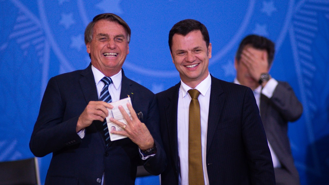 BRASILIA, BRAZIL - JUNE 27: Justice Minister Anderson Gustavo Torres hands over a new passport to President of Brazil Jair Bolsonaro during the ceremony to unveil a project for new national ID's and passports at Planalto Palace on June 27, 2022 in Brasilia, Brazil. (Photo by Andressa Anholete/Getty Images)