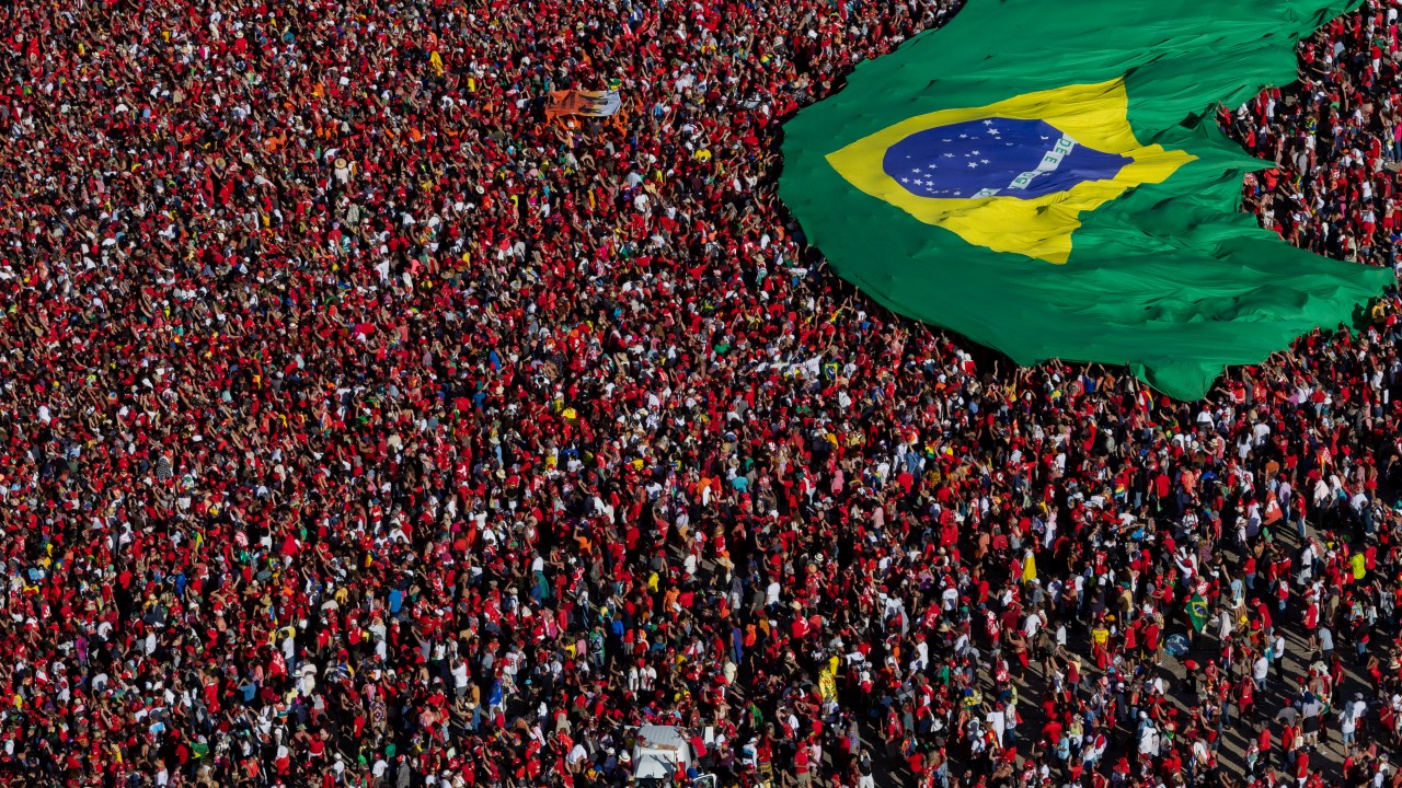 BRASILIA, BRAZIL - JANUARY 01: Supporters of President Luiz Inácio Lula Da Silva display a Brazilian flag during the presidential inauguration ceremony at Planalto Palace on January 1, 2023 in Brasilia, Brazil. At the age of 77 and after having spent 580 days in jail between 2018 and 2019, Luiz Inácio Lula Da Silva starts his third period as president of Brazil. (Photo by/Getty Images)