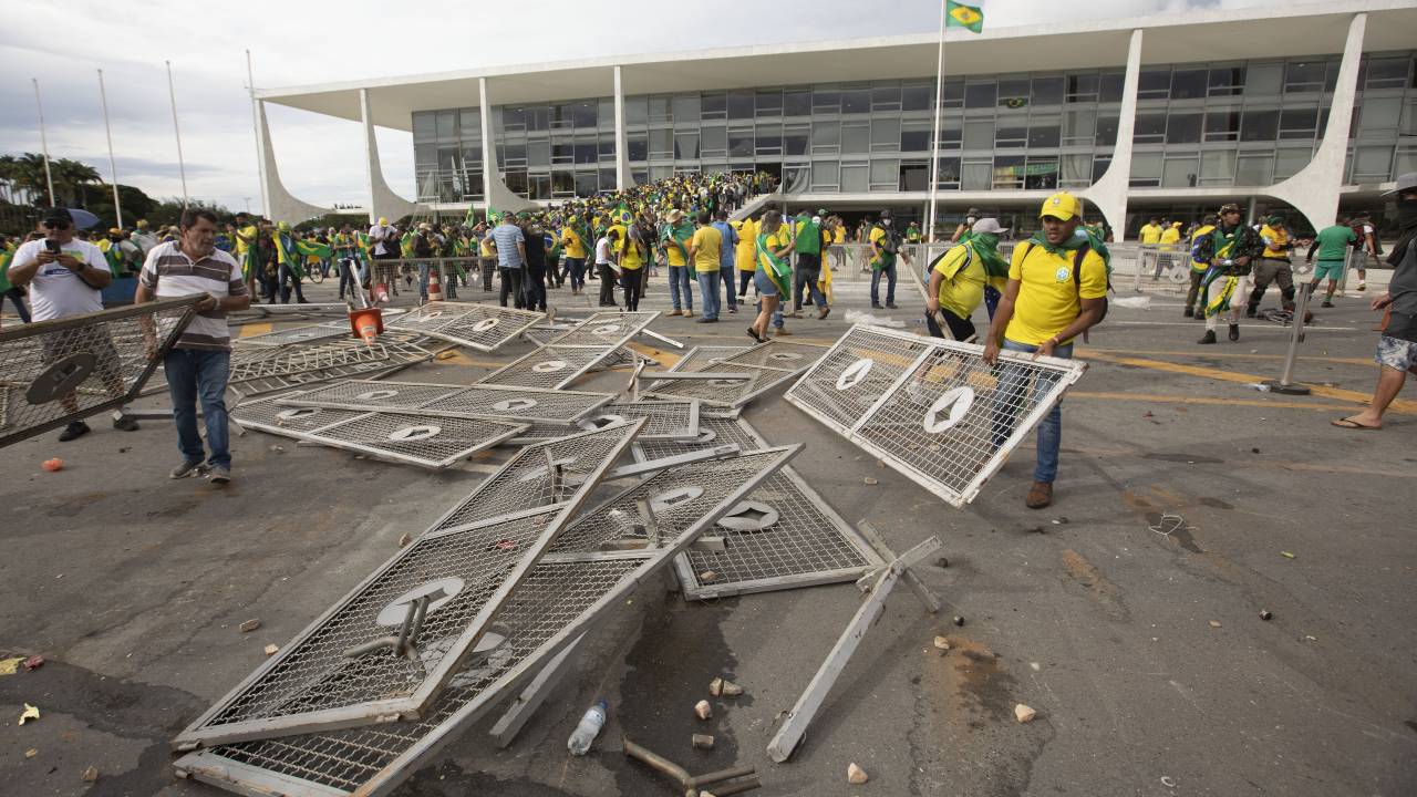 BRASILIA, BRAZIL - JANUARY 08: Supporters of former President Jair Bolsonaro clash with security forces as they break into Planalto Palace and raid Supreme Court in Brasilia, Brazil, 08 January 2023. Groups shouting slogans demanding intervention from the army broke through the police barrier and entered the Congress building, according to local media. Police intervened with tear gas to disperse pro-Bolsonaro protesters. Bolsonaro supporters managed to invade and ransack the National Congress, Planalto Palace, or President's office, and the Supreme Federal Court. (Photo by Joedson Alves/Anadolu Agency via Getty Images)