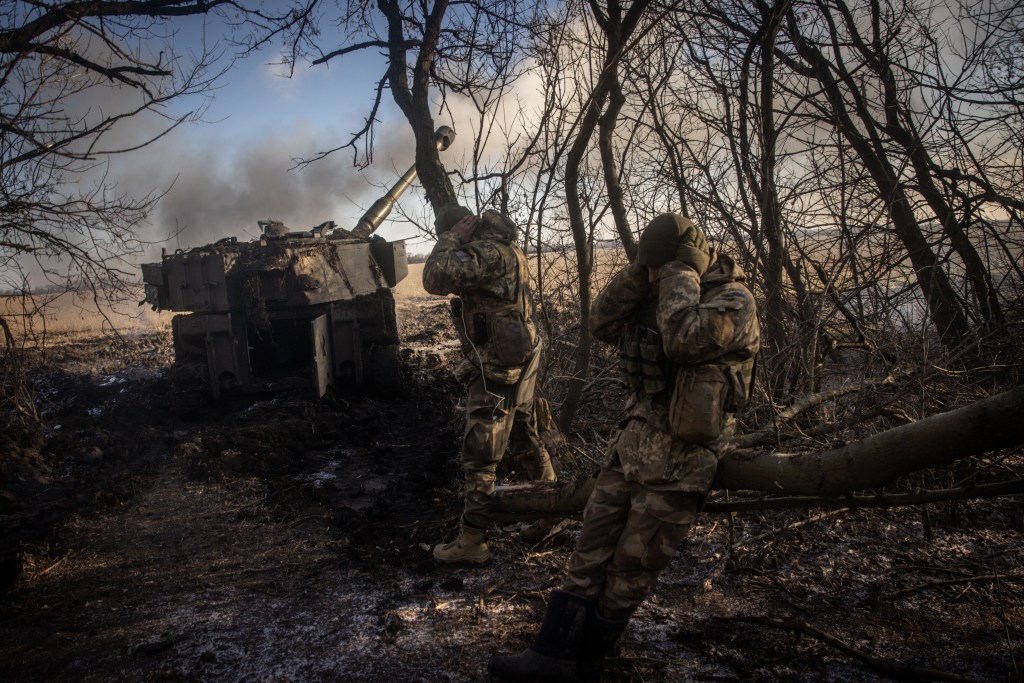 DONETSK, UKRAINE - DECEMBER 19: Members of a Ukrainian artillery unit cover their ears as an M109 self propelled artillery unit is fired at Russian mortar positions around Vuhledar from a frontline position on December 19, 2022 in Donetsk Region, Ukraine. A large swath of Donetsk region has been held by Russian-backed separatists since 2014. Russia has tried to expand its control here since the February 24 invasion. (Photo by Chris McGrath/Getty Images)