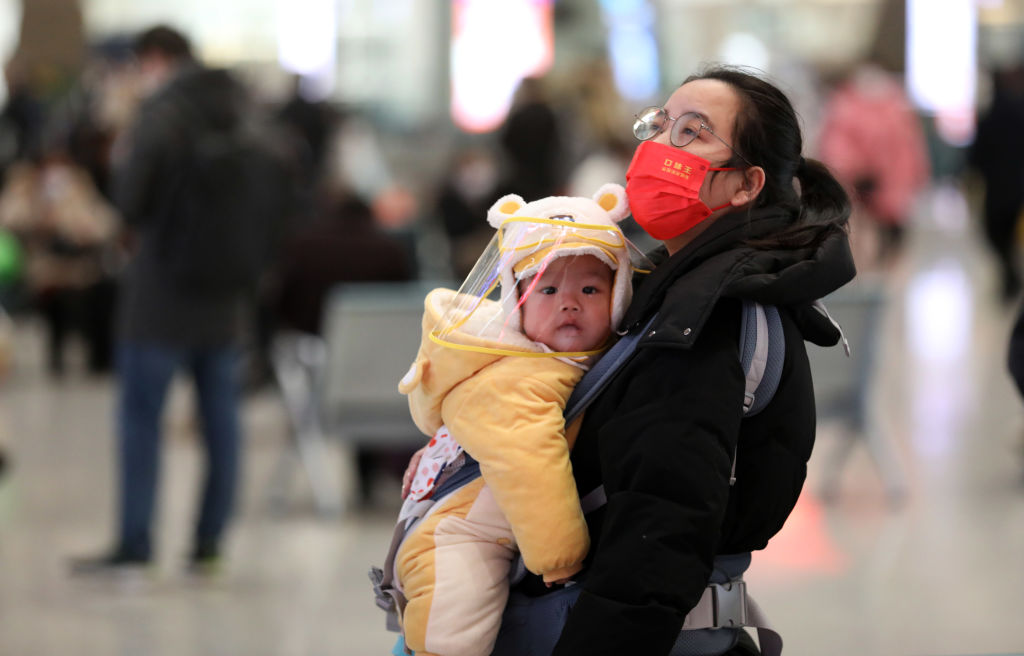 SHIJIAZHUANG, CHINA - JANUARY 07: A woman holds a baby at Shijiazhuang Railway Station on the first day of 2023 China's Spring Festival travel rush on January 7, 2023 in Shijiazhuang, Hebei Province of China. The 40-day Spring Festival travel rush officially starts on January 7. (Photo by VCG/VCG via Getty Images)
